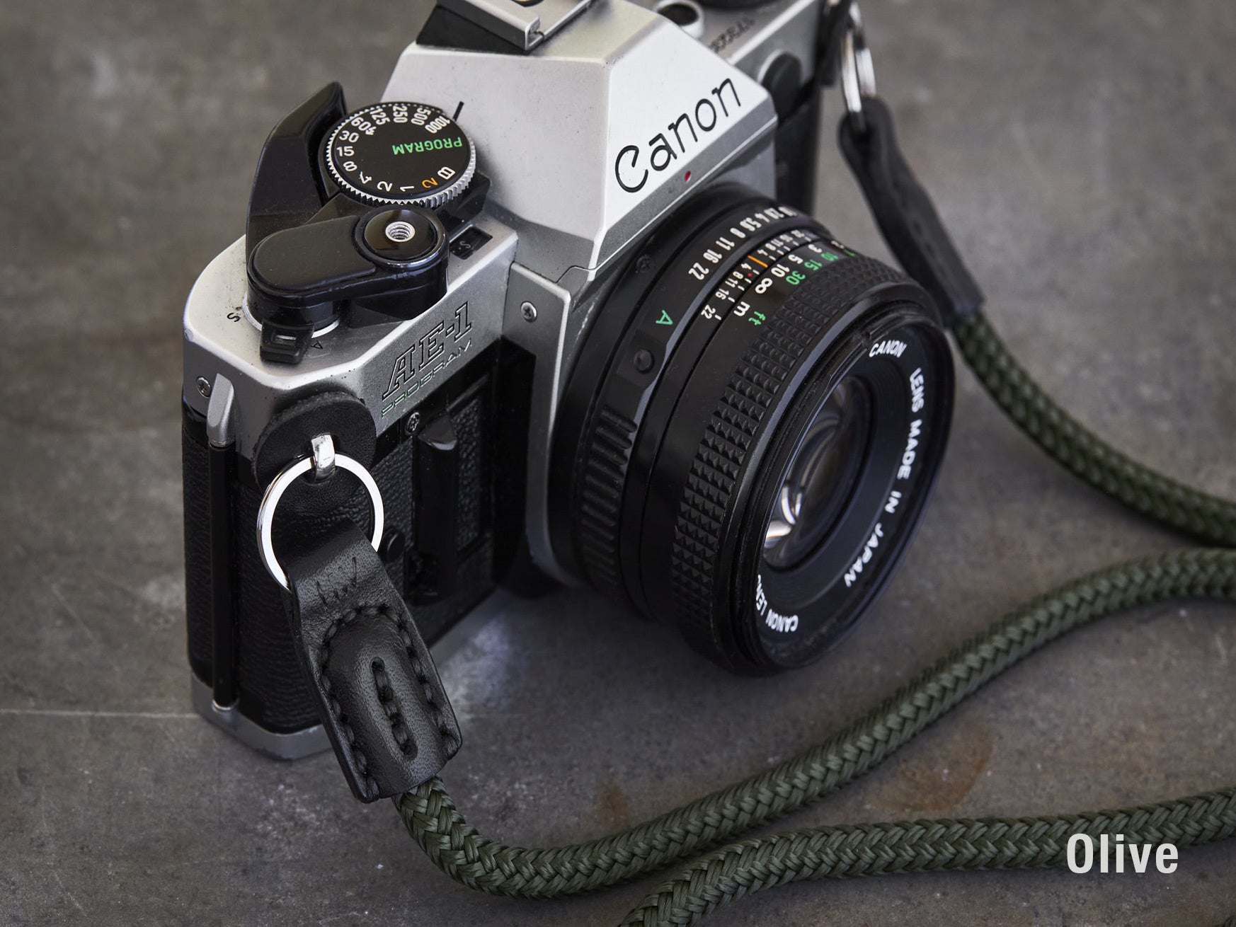 Henry and Wilde Standard Rope Camera Strap in Olive with hand sewn leather ends attached to a Canon AE-1 film camera.