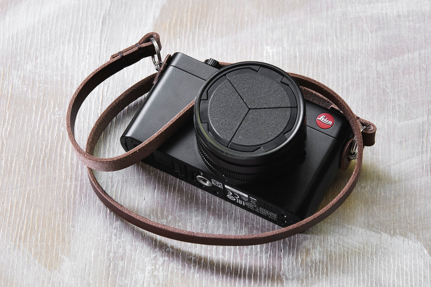 Henry and Wilde Vincent minimal 10mm leather camera strap attached to a compact Leica camera body.